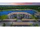 Aerial view of an apartment complex near a lake with sunset and golf course backdrop at 16904 Vardon Ter # 204, Bradenton, FL 34211