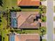 Birds eye view of a tile roof home with a screened-in pool and meticulously maintained landscaping at 1805 7Th St E, Palmetto, FL 34221