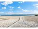 Beautiful beach view with a sandy path leading to the ocean under a blue sky with scattered clouds at 1805 7Th St E, Palmetto, FL 34221