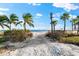 Scenic beach access with palm trees and blue sky providing a tropical and relaxing atmosphere at 1805 7Th St E, Palmetto, FL 34221