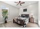 Bedroom with hardwood floors, ceiling fan, two bedside lamps, and a large window for natural light to shine through at 1805 7Th St E, Palmetto, FL 34221