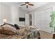 Bedroom with hardwood floors, ceiling fan, tv, white sliding door closet, and large comfortable bed at 1805 7Th St E, Palmetto, FL 34221