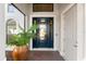 Inviting front entrance with a dark blue door, brick landing, tropical plants, and transom window at 1805 7Th St E, Palmetto, FL 34221