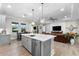 Open concept kitchen with gray cabinets, stainless steel appliances, island, and an adjacent living room at 1805 7Th St E, Palmetto, FL 34221