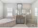 Bright bathroom features a walk-in shower, a soaking tub, and a vanity with a mirror at 1805 7Th St E, Palmetto, FL 34221