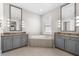 Bright main bathroom features a soaking tub, gray cabinetry, tile floors, and double sinks at 1805 7Th St E, Palmetto, FL 34221