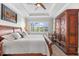 This main bedroom boasts hardwood floors, a ceiling fan, a window, and wood wardrobe at 1805 7Th St E, Palmetto, FL 34221