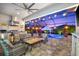 Relaxing outdoor patio includes a full kitchen, comfortable seating, and views of the pool area at sunset at 1805 7Th St E, Palmetto, FL 34221