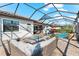 A spacious screened-in pool area with an outdoor kitchen, ample seating and a luxurious fire pit at 1805 7Th St E, Palmetto, FL 34221