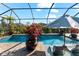 Screened-in pool area featuring a pool, lounge chairs, plants, and an umbrella, with a blue sky above at 1805 7Th St E, Palmetto, FL 34221