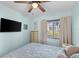 Serene bedroom with soft blue walls, a flatscreen TV, and bright window letting in natural light at 1807 Sunny Dr # E4, Bradenton, FL 34207