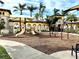 Community playground with slides, swings, and climbing structures set among swaying palm trees at 20080 Ragazza Cir # 102, Venice, FL 34293