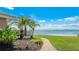 Pathway leading to a serene waterfront view, complemented by lush landscaping and clear blue skies at 202 Gaines Ave, Sarasota, FL 34243