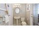 Bathroom featuring a pedestal sink, decorative mirror, and silver patterned walls at 202 Gaines Ave, Sarasota, FL 34243