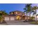 Elegant two-story home with a three-car garage, lush landscaping, and a circular driveway at dusk at 202 Gaines Ave, Sarasota, FL 34243