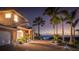 Inviting home exterior at dusk with lush landscaping, a brick driveway, and distant water views at 202 Gaines Ave, Sarasota, FL 34243