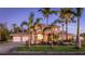 Beautiful two-story home with a three-car garage, lush landscaping, and an elegant entrance at twilight at 202 Gaines Ave, Sarasota, FL 34243