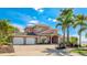 Stately two-story home with a three-car garage, columns, and lush landscaping on a sunny day at 202 Gaines Ave, Sarasota, FL 34243