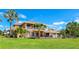 Beautiful exterior view of the two-story home with a manicured lawn, mature palm trees and landscaping at 202 Gaines Ave, Sarasota, FL 34243