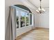 Sunlit living area with a large arched window overlooking the lush landscaping at 202 Gaines Ave, Sarasota, FL 34243
