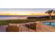 Inviting outdoor patio area with comfortable seating and a view of the serene waterfront and pool at sunset at 202 Gaines Ave, Sarasota, FL 34243