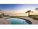 Backyard pool overlooks a sunset ocean view at twilight in this scenic yard at 202 Gaines Ave, Sarasota, FL 34243