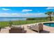 A brick patio overlooks the ocean view with furniture by the pool at 202 Gaines Ave, Sarasota, FL 34243