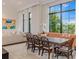 Bright dining area with rustic table, woven chairs, and a view of tropical greenery at 212 Haverkos Ct, Holmes Beach, FL 34217