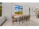 Elegant dining room with a rustic table, seating for eight, and lots of light at 212 Haverkos Ct, Holmes Beach, FL 34217