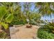 Enjoy the cozy outdoor fire pit area with lush landscaping and swaying palm trees, offering a private retreat at 212 Haverkos Ct, Holmes Beach, FL 34217