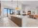 Modern kitchen flows to living spaces and has water views from the large windows at 212 Haverkos Ct, Holmes Beach, FL 34217