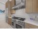 Well-equipped kitchen with stainless steel range and hood, quartz counters, and light wood cabinets at 212 Haverkos Ct, Holmes Beach, FL 34217