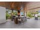 Outdoor kitchen boasts a built-in grill, bar seating, under-counter refrigerator, and tropical landscaping around the water at 212 Haverkos Ct, Holmes Beach, FL 34217