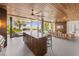Entertain easily from this outdoor kitchen, complete with an island, grill and views of the living area and waterfront at 212 Haverkos Ct, Holmes Beach, FL 34217