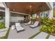 Beautiful outdoor lounge area with stylish chaise lounges, a modern kitchen, and lush tropical foliage at 212 Haverkos Ct, Holmes Beach, FL 34217