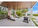 Tranquil outdoor lounge space featuring chaise lounges and views of the bay with lush, tropical landscaping at 212 Haverkos Ct, Holmes Beach, FL 34217