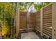 Private outdoor shower with wooden slat enclosure surrounded by lush greenery at 212 Haverkos Ct, Holmes Beach, FL 34217