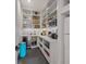 This modern pantry features custom shelving and cabinets and an under counter wine cooler at 212 Haverkos Ct, Holmes Beach, FL 34217