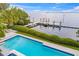 Aerial view of a luxurious pool overlooking bay waters with a private boat dock at 212 Haverkos Ct, Holmes Beach, FL 34217