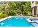 Backyard swimming pool with integrated spa, deck chairs, and tropical landscaping that create private oasis at 212 Haverkos Ct, Holmes Beach, FL 34217