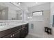 Bright bathroom with a double sink vanity, frameless mirror, glass shower enclosure, and bench seating at 220 Cassano Dr, Nokomis, FL 34275