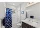 Well-lit bathroom with vanity, sink, and bathtub with blue patterned shower curtain at 220 Cassano Dr, Nokomis, FL 34275