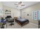 Neutral bedroom with desk space, ceiling fan, and comfortable bed with view outside window at 220 Cassano Dr, Nokomis, FL 34275