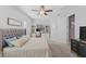 Bright bedroom with neutral colors, built-in shelves, ceiling fan, and tufted upholstered headboard at 220 Cassano Dr, Nokomis, FL 34275