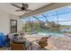 Covered outdoor pool area with a jacuzzi, lounge furniture, ceiling fan and a view of the lake at 220 Cassano Dr, Nokomis, FL 34275