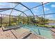 A screened in pool and jacuzzi with a stunning view of the lake at 220 Cassano Dr, Nokomis, FL 34275