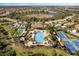 Stunning aerial view of a community pool surrounded by palm trees and amenities, inviting relaxation and recreation at 220 Cassano Dr, Nokomis, FL 34275