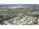 Wide aerial shot of the property and surrounding neighborhood with mature trees and clear blue skies at 2406 Breakwater Cir, Sarasota, FL 34231