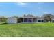 Spacious backyard with a screened-in porch, shed, and manicured lawn at 2406 Breakwater Cir, Sarasota, FL 34231