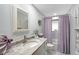 Charming bathroom featuring marble countertops, a framed mirror, and bathtub with shower at 2406 Breakwater Cir, Sarasota, FL 34231